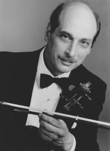A man in a tuxedo holding a violin.